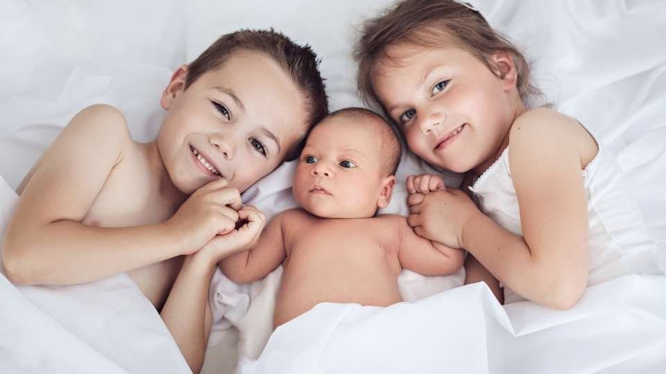 3 niños en una cama