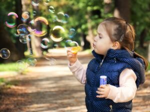 Niña soplando pompero