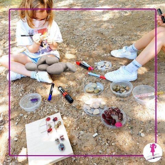 niñas pintando piedras en el río