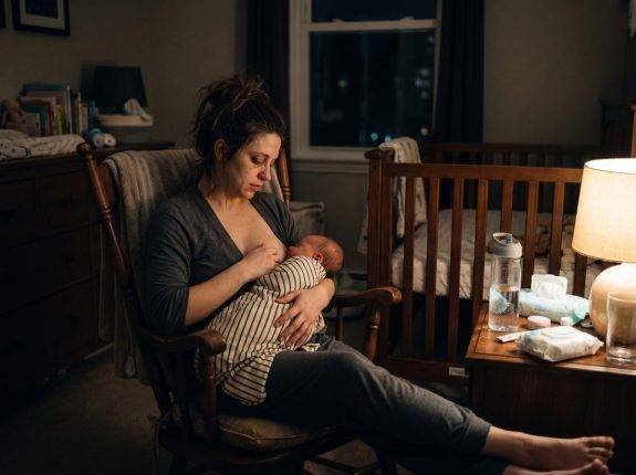 Madre amamantando bebé de noche mecedora habitación — Los Mundos de Noa