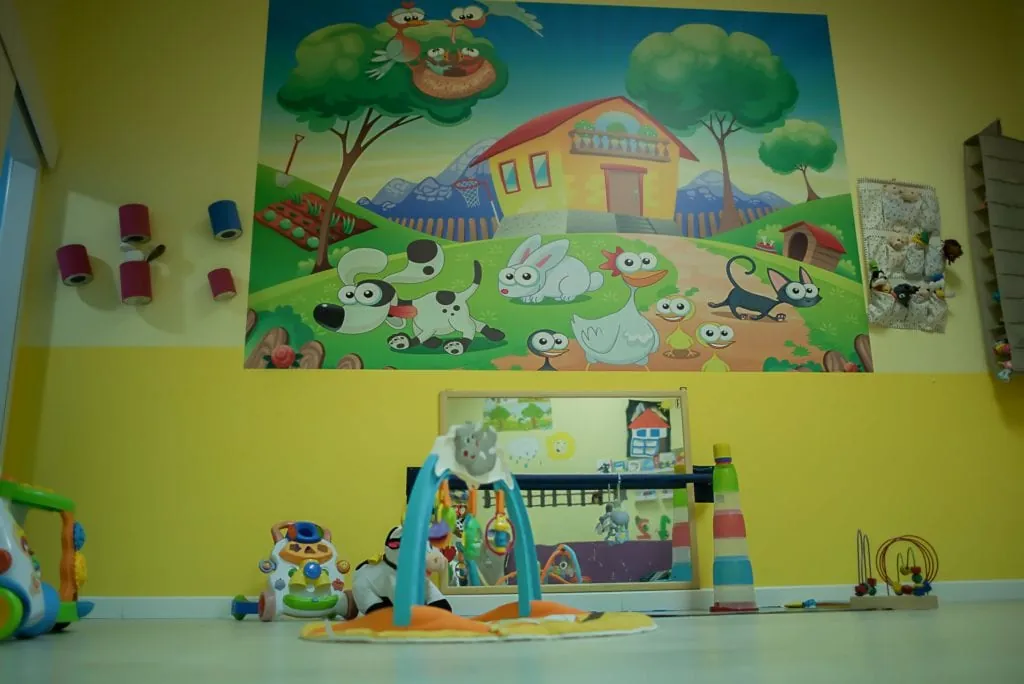 Espejo a la altura del suelo y mural de la granja en el Aula Amarilla