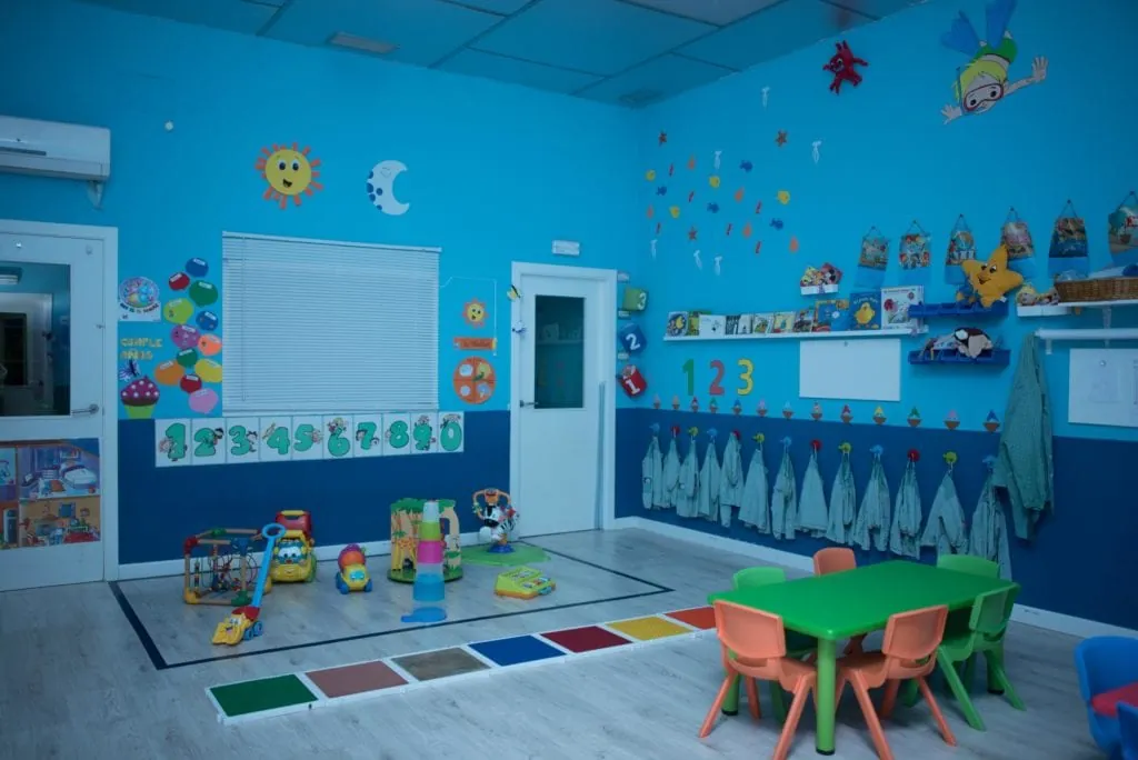 Aula Azul con mesa y sillas infantiles, juguetes y camino sensorial de colores