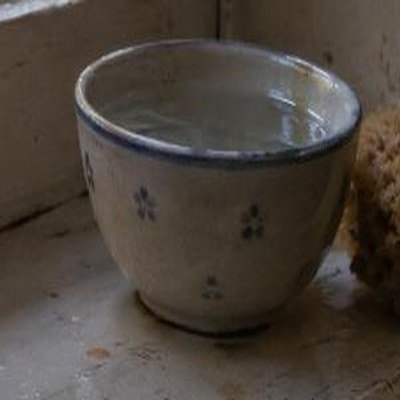 Bol de cerámica con agua sobre el alféizar de la ventana