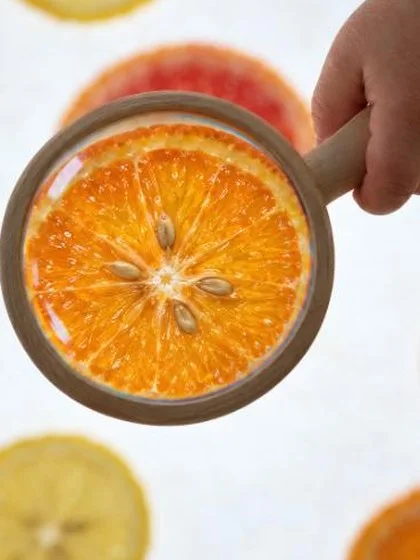 Lupa de mano con mango de madera sobre la mesa de luz
