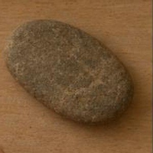 Piedra plana y lisa de río sobre la bandeja de madera