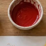 Témpera roja en un vasito
