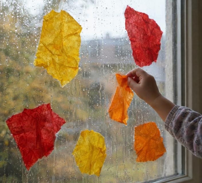 Bebé despegando y volviendo a pegar un trozo de papel de seda en la ventana mientras cambia la luz