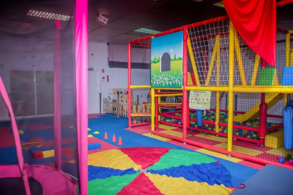 Piscina de bolas con tobogán y paracaídas de colores en la sala de psicomotricidad de la escuela infantil
