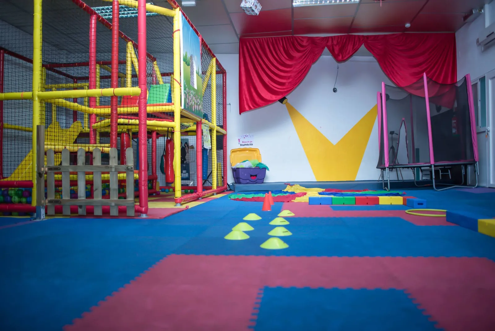 Sala de psicomotricidad con piscina de bolas, circuito de conos, escenario y rincón de disfraces en la guardería Los Mundos de Noa, Albacete