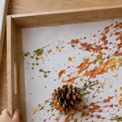 Bandeja de madera con bordes altos y un folio pintado con piñas