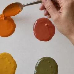 Gotas de témpera naranja, roja, amarilla y verde sobre el folio